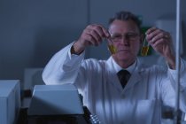Homme scientifique plaçant des flacons médicaux sur une machine de laboratoire en laboratoire — Photo de stock