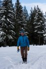 Mann mit Hundehalsband steht im Winter in verschneiter Landschaft — Stockfoto