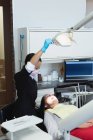 Dentista feminina examinando uma paciente na clínica odontológica — Fotografia de Stock