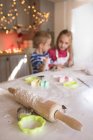 Rolling pin and cookie cutter in the kitchen and siblings in background — Stock Photo