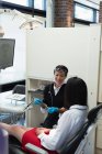 Dentista interagindo com um paciente na clínica odontológica — Fotografia de Stock