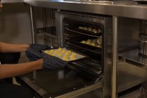 Шеф-повар кладет печенье в духовку в ресторане — стоковое фото