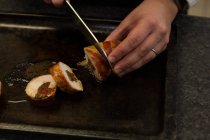 Gros plan du chef qui coupe le bacon au couteau au restaurant — Photo de stock