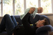 Vater spielt mit seinem kleinen Jungen im heimischen Wohnzimmer — Stockfoto