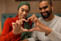 Happy couple making heart symbol with hands — Stock Photo