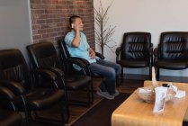 Мужчина разговаривает по мобильному телефону в стоматологической клинике — стоковое фото