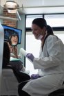 Женщина-дантист взаимодействует с пациентом в клинике — стоковое фото