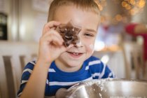 Крупный план улыбающегося мальчика, показывающего нож для печенья — стоковое фото