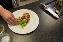 Primo piano dello chef che dispone la pancetta su un piatto — Foto stock