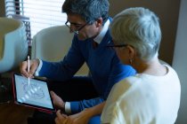 Оптометрист обговорює графічний планшет з пацієнтом у клініці — стокове фото