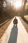Батько зі своїм маленьким хлопчиком у колясці в парку в сонячний день — стокове фото