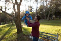 Pai segurando seu menino no parque em um dia ensolarado — Fotografia de Stock