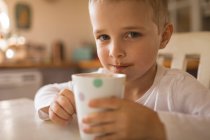Retrato de menino tomando uma xícara de bebida — Fotografia de Stock