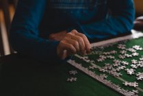 Середня частина старшої жінки грає головоломки вдома — стокове фото