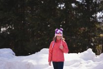 Menina em pé em uma região nevada durante o inverno — Fotografia de Stock