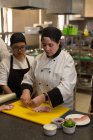 Chef donna che taglia carne sul tagliere in cucina al ristorante — Foto stock