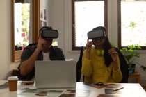 Colegas de negócios usando headset de realidade virtual na mesa no escritório — Fotografia de Stock