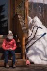 Девушка, использующая мобильный телефон зимой в солнечный день — стоковое фото