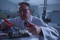 Scienziato maschio circuito di saldatura in laboratorio — Foto stock