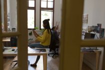 Боковой вид женщины-руководителя с помощью цифрового планшета в офисе — стоковое фото