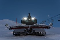 Chariot de chasse-neige moderne en saison enneigée la nuit — Photo de stock