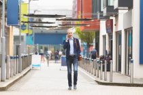 Бізнесмен розмовляє по мобільному телефону під час прогулянки по місту — стокове фото