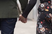 Milieu Section de couple marchant main dans la main dans la rue de la ville — Photo de stock