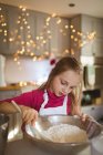 Девочка готовит тесто для рождественского печенья дома — стоковое фото