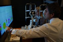 Optometrist que explica o relatório da visão na tela na clínica — Fotografia de Stock