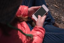 Крупный план девушки с помощью мобильного телефона в солнечный день — стоковое фото
