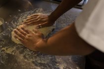 Parte centrale dello chef impastare pasta in cucina al ristorante — Foto stock