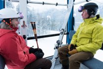 Smiling couple travelling into ski lift — Stock Photo