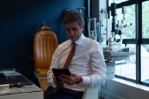 Optometrista masculino usando tablet digital na clínica — Fotografia de Stock