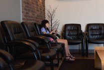 Menina atenta usando tablet digital na clínica odontológica — Fotografia de Stock