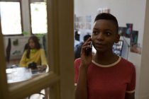 Jeune femme cadre parlant sur téléphone portable au bureau — Photo de stock
