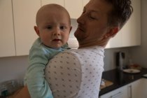 Vater hält seinen kleinen Jungen zu Hause in der Küche — Stockfoto