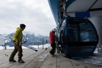 Paar mit Skiboard steigt im Winter in Skilift ein — Stockfoto