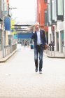 Empresário falando no celular enquanto caminha na cidade — Fotografia de Stock