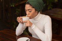 Belle femme prenant un café dans un café — Photo de stock
