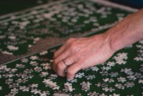 Close-up de homem sênior jogando jogo de quebra-cabeça em casa — Fotografia de Stock
