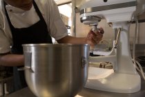 Женщина шеф-повар с помощью замесительной машины на кухне в ресторане — стоковое фото