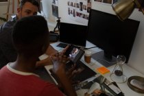 Деловые коллеги обсуждают за цифровым планшетом на столе в офисе — стоковое фото