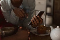 Крупный план пары с использованием мобильного телефона в кафе — стоковое фото