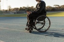 Vista laterale di atletica disabili utilizzando tablet digitale presso la sede sportiva — Foto stock