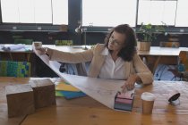 Жінка-виконавця, що працює на відбитках за столом в офісі — стокове фото