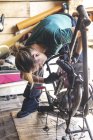 Nahaufnahme einer Mechanikerin, die ein Motorrad in der Garage repariert — Stockfoto