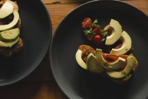 Abacate fatiado e cereja servida em prato no café — Fotografia de Stock