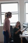 Дві бізнес-леді обговорюють документ в офісі — стокове фото