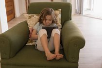 Дівчина використовує цифровий планшет у вітальні вдома — стокове фото