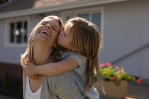 Happy mother giving piggyback ride to her daughter in the porch — Stock Photo